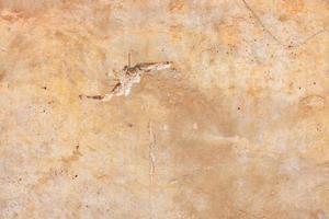 Texture of an old clay wall with cracks and scratches. photo