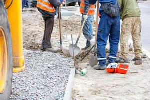 un grupo de constructores está planeando las marcas para pavimentar la acera, llenando de escombros el camino futuro. foto