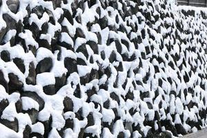 stone wall covered with snow i photo