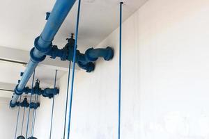 blue pipe line with blue valve on  wall photo