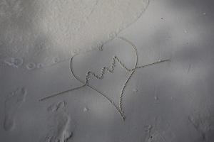 hearts drawn on the sand of a beach photo