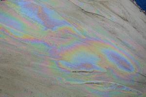 petróleo crudo en agua de mar y reflejo del arco iris foto