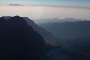 niebla y montaña volcánica durante el amanecer tomada desde el punto de vista pinajagun ii, indonesia foto