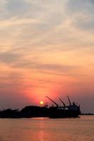 Cargo ship in the harbor at sunset photo