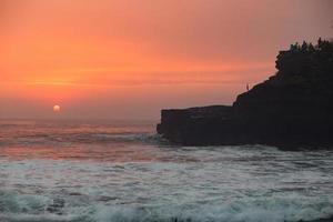 puesta de sol sobre el templo hindú pura tanah lot, bali, indonesia foto