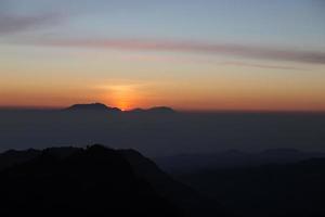 niebla y montaña volcánica durante el amanecer tomada desde el punto de vista pinajagun ii, indonesia foto