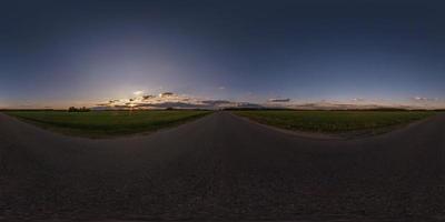 Panorama esférico completo sin costuras 360 grados de ángulo de visión en carretera asfaltada sin tráfico entre campos por la noche antes de la puesta del sol con cielo despejado. Panorama 360 en proyección equirrectangular, contenido vr ar foto