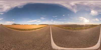 Full spherical seamless hdri panorama 360 degrees angle view on no traffic asphalt road among fields in spring day with cloudy evening in equirectangular projection, VR AR content photo