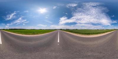 vista de ángulo de 360 grados de panorama hdri esférico completo en carretera asfaltada sin tráfico entre campos con cielo nublado en proyección equirectangular, contenido vr ar foto