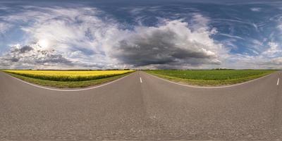 vista de ángulo de 360 grados de panorama hdri esférico completo en carretera asfaltada sin tráfico entre campos con cielo nublado en proyección equirectangular, contenido vr ar foto