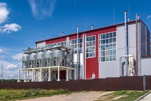 Modern Granary elevator. Silver silos on agro-processing and manufacturing plant for processing drying cleaning and storage of agricultural products, flour, cereals and grain. photo