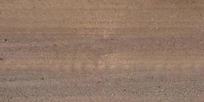 view from above on texture of gravel road with car tire tracks photo