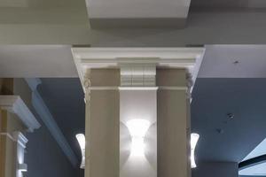 Detail of corner ceiling with intricate crown molding on column with spot light photo