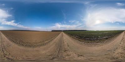 panorama hdri esférico completo sin costuras vista en ángulo de 360 grados en camino de grava sin tráfico entre campos en primavera con cielo despejado en proyección equirectangular, listo para contenido de realidad virtual vr ar foto