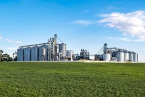 Modern Granary elevator. Silver silos on agro-processing and manufacturing plant for processing drying cleaning and storage of agricultural products, flour, cereals and grain. photo