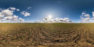 panorama hdri esférico completo sin costuras vista en ángulo de 360 grados en camino de grava entre campos en primavera con impresionantes nubes en proyección equirectangular, listo para contenido de realidad virtual vr ar foto