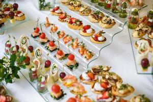 Catering. Off-site food. Buffet table with various canapes, sandwiches, hamburgers and snacks. photo