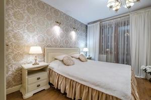 Interior of the modern luxure bedroom with pillows on the bed in studio apartments in light color style photo