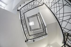 white stairs  emergency and evacuation exit spiral stair in up ladder in a new office building photo