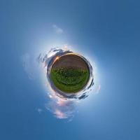 Little planet transformation of spherical panorama 360 degrees. Spherical abstract aerial view in field with awesome beautiful clouds. Curvature of space. photo