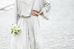 elementos de un traje casual de mujer con un ramo de calas foto