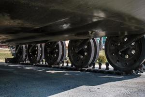 tracks and wheels of tank, armored vehicles on the street in green khaki color photo