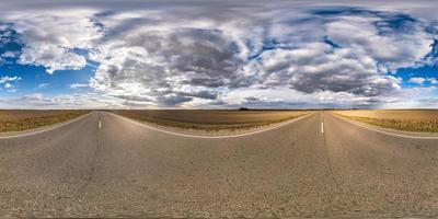 Panorama esférico completo sin costuras Vista angular de 360 grados en carretera asfaltada sin tráfico entre campos por la noche antes de la puesta del sol con cielo nublado. Panorama 360 en proyección equirrectangular, contenido vr ar foto