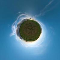 Little planet transformation of spherical panorama 360 degrees. Spherical abstract aerial view in field with evening awesome beautiful clouds. Curvature of space. photo