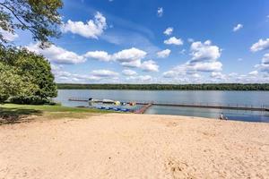 pier on the shore of a large lake in summer day with beautiful clouds.  sky reflection photo