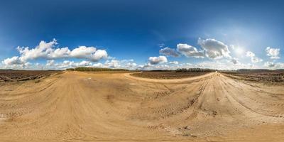 panorama hdri esférico completo sin costuras vista en ángulo de 360 grados en camino de grava entre campos en primavera con impresionantes nubes en proyección equirectangular, listo para contenido de realidad virtual vr ar foto