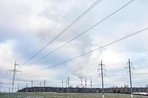 Silhouette of the high voltage electric pylon towers on the background of beautiful clouds photo