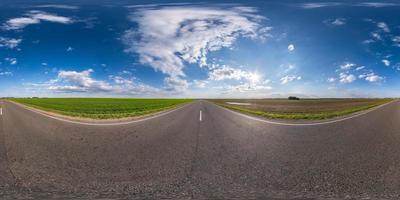 vista de ángulo de 360 grados de panorama hdri esférico completo sin tráfico en carretera asfaltada entre campos con cielo azul claro en proyección equirectangular, contenido vr ar foto