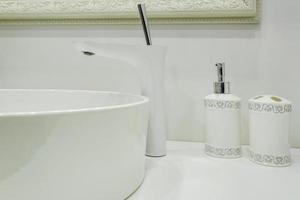 Soap and shampoo dispensers near Ceramic Water tap sink with faucet in expensive loft bathroom photo