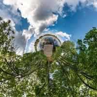 Little planet transformation of spherical panorama 360 degrees. Spherical abstract aerial view in field with awesome beautiful clouds. Curvature of space. photo