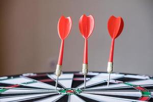 Red and yellow dart arrows hitting in the target center of dartboard. Success hitting target aim goal achievement concept photo