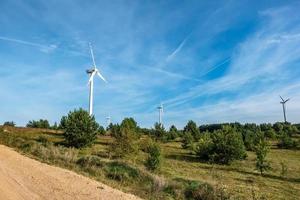 rotating blades of a windmill propeller on blue sky background. Wind power generation. Pure green energy. photo