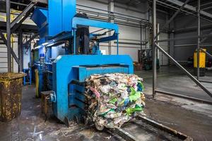 Equipment for pressing debris sorting material to be processed in modern waste recycling plant. garbage press on modern waste recycling processing plant. Business for sorting and processing of waste. photo