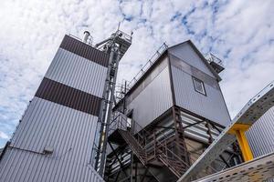 ascensor de granero moderno. silos de plata en la planta de procesamiento y fabricación de productos agrícolas para el procesamiento, secado, limpieza y almacenamiento de productos agrícolas, harina, cereales y granos. foto