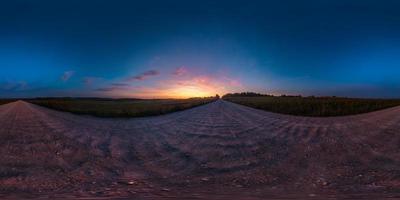 panorama hdri esférico completo sin costuras vista en ángulo de 360 grados en la carretera asfaltada entre campos en la puesta de sol de la tarde de verano con nubes impresionantes en proyección equirectangular, listo para la realidad virtual vr ar foto