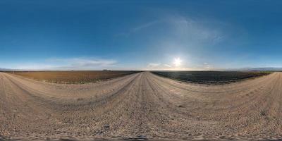 vista de ángulo de 360 grados de panorama hdri esférico completo sin costuras en camino de grava entre campos en el día de otoño con sol en cielo despejado en proyección equirectangular, listo para contenido de realidad virtual vr ar foto