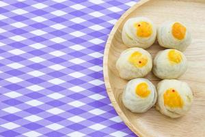 Chinese Pastry Mung Bean or Mooncake with Egg Yolk on wooden dish striped cloth