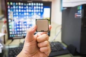 cpu en mano con computadora de escritorio en el fondo de la oficina. enfoque suave foto