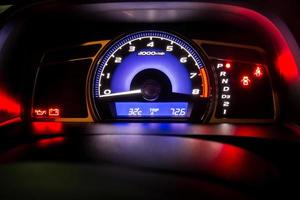 Modern car instrument dashboard panel in night time photo