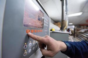 carpintero calculando y programando una máquina de trabajo de madera cnc foto