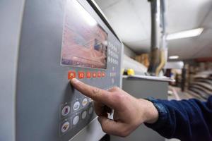 carpintero calculando y programando una máquina de trabajo de madera cnc foto