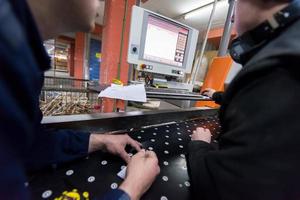 carpenters calculating and programming a cnc wood working machine photo