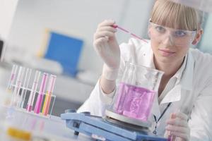 female researcher holding up a test tube in lab photo