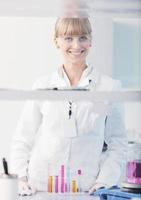 female researcher holding up a test tube in lab photo