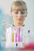 female researcher holding up a test tube in lab photo