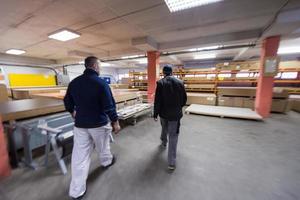 two young carpenters working in big modern carpentry photo